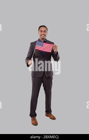 Geschäftsmann Mit Amerikanischer Flagge. Indische Geschäftsmann stehend voller Länge mit USA Flagge in den Händen Stockfoto