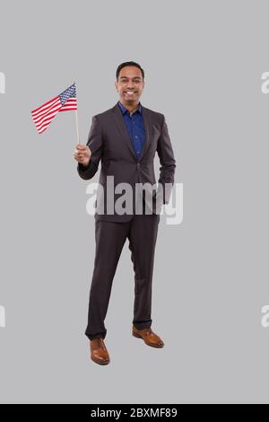 Geschäftsmann Winkt Amerikanische Flagge. Indische Geschäftsmann stehend voller Länge mit USA Flagge in den Händen Stockfoto