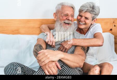 Ältere Paar genießen Zeit zusammen zu Hause nach dem Aufwachen - Senior Mann und Frau mit zarten Momente sitzen im Bett - Liebe und freudige ältere lif Stockfoto