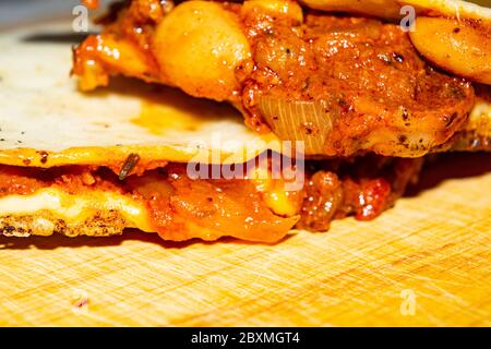 Quesadilla mit Hackfleisch, Wurst, roten Bohnen, Mais, Zwiebeln und Tomatensauce. Ein traditionelles mexikanisches Essen. Nahaufnahme Stockfoto