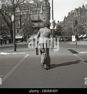 Spaß in den 1940er Jahren. Ein junger Mann mit Rollschuh. Wenn er sich in einem Anzug und in einer Aktentasche befindet, ist er auf dem Weg ins Büro. Er rollt in der Straße von Stockholm. Schweden 1943. Kristoffersson Ref. D61-1 Stockfoto