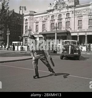 Spaß in den 1940er Jahren. Ein junger Mann mit Rollschuh. Wenn er sich in einem Anzug und in einer Aktentasche befindet, ist er auf dem Weg ins Büro. Er rollt in der Straße von Stockholm. Schweden 1943. Kristoffersson Ref. D60-4 Stockfoto