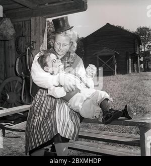 Edgar Bergen. Geboren am 16. februar 1903 bis september 30 1978. Amerikanischer Schauspieler, Komiker und Radiodarsteller. Am besten bekannt für seine Fähigkeiten im Ventriloquismus und seine Charaktere Charlie McCarthy und Mortimer Snerd. Er war der Vater der Schauspielerin Candice Bergen. Als Kind schwedischer Einwanderer besucht er hier das alte Land Schweden 1948. Hier ein Mädchen aus Leksand Dalarna, das mit Charlie McCarthy abgebildet wurde. Kristoffersson ref AL21-11 Ventriloquist Stockfoto