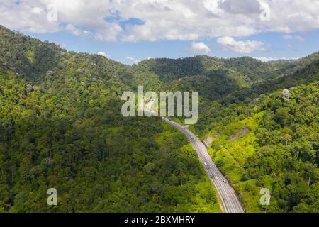 Luftaufnahme des schönen Nord-Süd-Highway durch gebirgigen tropischen Dschungel im Perak State, Malaysia Stockfoto