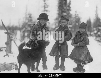 Sami im schwedischen Lappland 1910. Drei kleine sami-Kinder mit Hund i Gällivare, Lappland, Schweden Stockfoto