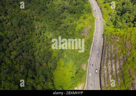 Luftaufnahme des schönen Nord-Süd-Highway durch gebirgigen tropischen Dschungel im Perak State, Malaysia Stockfoto