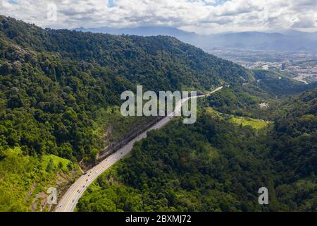 Luftaufnahme des schönen Nord-Süd-Highway durch gebirgigen tropischen Dschungel im Perak State, Malaysia Stockfoto