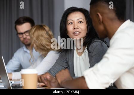 Asiatische mittleren Alters Frau Mentor lehren afrikanischen Kerl Millennial intern Stockfoto