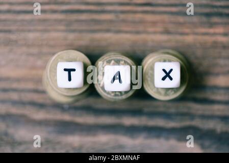 Tax Konzept mit Blocksteuer auf gestapelte Münzen, Draufsicht Stockfoto