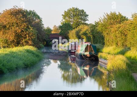 Narrowboats auf dem oxford Kanal bei Sonnenaufgang. Napton on the Hill, Warwickshire, England Stockfoto