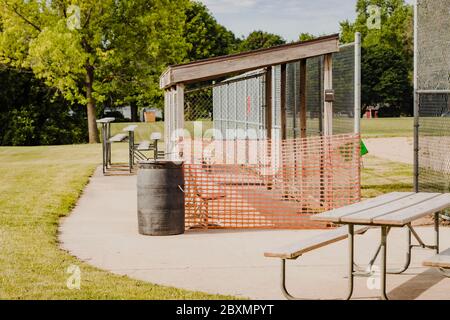 Die Dugouts auf diesem Baseballfeld werden durch Stadtordnung in diesem Stadtpark-Feld geschlossen Stockfoto