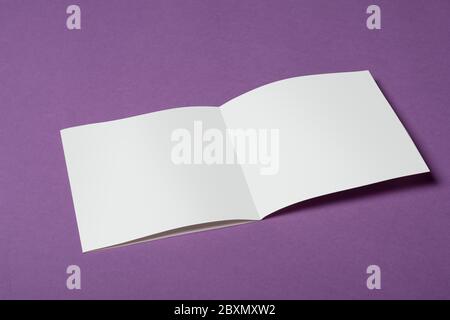 Ein geöffneter quadratischer dreifacher Katalog auf purpurfarbenem Hintergrund, Modell-up-Serie Vorlage bereit für Ihr Design, Seiten Auswahlpfad enthalten Stockfoto