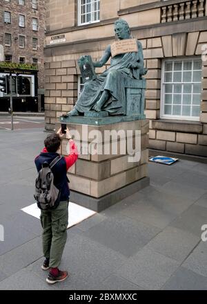 Ein Plakat hängt an der Statue des Philosophen David Hume aus dem 18. Jahrhundert auf der Royal Mile, Edinburgh, nach der Protestkundgebung von Black Lives Matter am 7. Juni 2020 im Holyrood Park, Edinburgh, In Erinnerung an George Floyd, der am 25. Mai in Polizeigewahrsam in der US-Stadt Minneapolis getötet wurde. Stockfoto