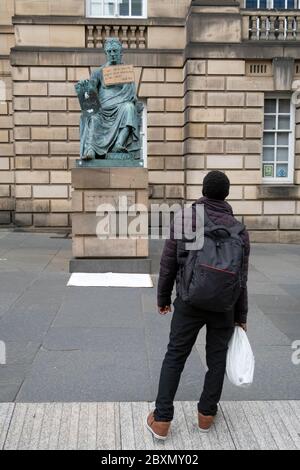 Ein Plakat hängt an der Statue des Philosophen David Hume aus dem 18. Jahrhundert auf der Royal Mile, Edinburgh, nach der Protestkundgebung von Black Lives Matter am 7. Juni 2020 im Holyrood Park, Edinburgh, In Erinnerung an George Floyd, der am 25. Mai in Polizeigewahrsam in der US-Stadt Minneapolis getötet wurde. Stockfoto