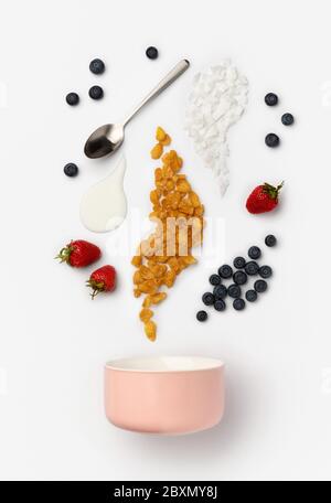 Beere, Cornflakes und Joghurt gießt in Keramikschale Stockfoto