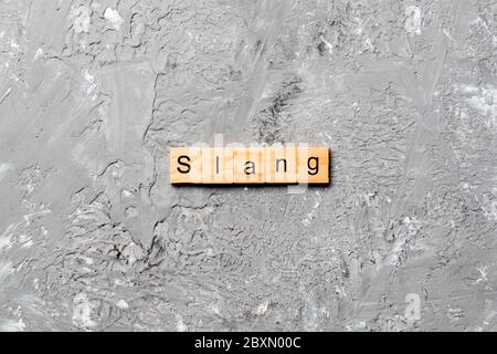 Slang Word auf Holz Block geschrieben. slang Text auf Tisch, Konzept. Stockfoto