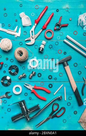 Sanitär-Toolset flach legen Ansicht auf blauem Holzhintergrund Stockfoto