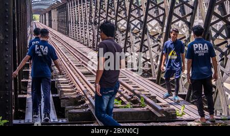 Malaysische Jugendliche, die eine alte verlassene Eiseneisenbahnbrücke in Kuala Kangsar, Perak, Malaysia erkunden Stockfoto