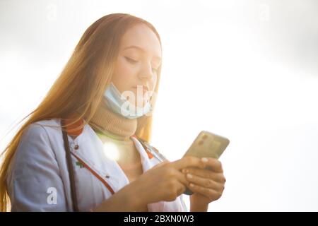 Junge Ärztin SMS mit Smartphone während der Pause Stockfoto