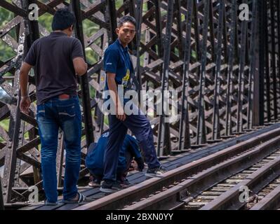 Malaysische Jugendliche, die eine alte verlassene Eiseneisenbahnbrücke in Kuala Kangsar, Perak, Malaysia erkunden Stockfoto