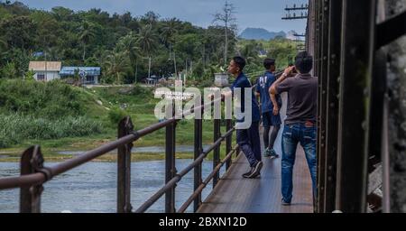 Malaysische Jugendliche, die eine alte verlassene Eiseneisenbahnbrücke in Kuala Kangsar, Perak, Malaysia erkunden Stockfoto