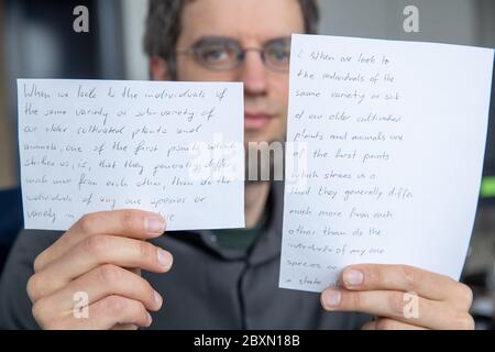 05. Juni 2020, Bayern, Erlangen: Vincent Christlein, Informatiker und wissenschaftlicher Mitarbeiter am Lehrstuhl für Mustererkennung an der Universität Erlangen-Nürnberg, hält Ausdrucke eines Mustertextes in seinen Händen. Der Text links ist handschriftlich, der Text rechts ist ein automatisch generierter Text mit dem Algorithmus zur Handschriftimitate im Stil des Originals. Erlangen-Forscher imitieren mit künstlicher Intelligenz die Handschrift. Ein Ziel ist es, Menschen zu ermöglichen, Texte in eigener Handschrift zu schreiben, die sich aufgrund von Verletzungen oder anderem ich nicht mehr selbst schreiben können Stockfoto