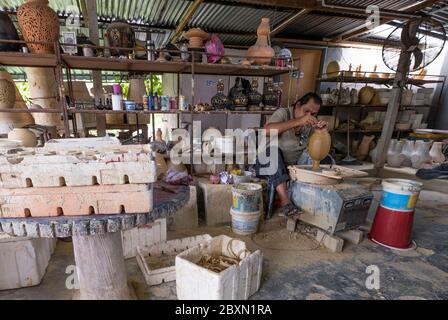 Mann, der einen Tonwasserbehälter in einer Töpferwerkstatt in Kuala, Kangsar, Perak, Malaysia, schnitzt Stockfoto