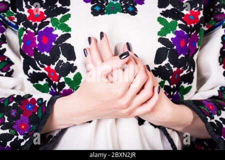 Frau in einem alten ukrainischen bestickten Hemd, Fragment. Maniküre mit schwarzem Nagellack Stockfoto