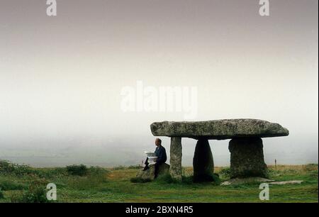 Walker macht eine Pause bei Lanyon Quoit Standing Stones Cornwall UK Stockfoto