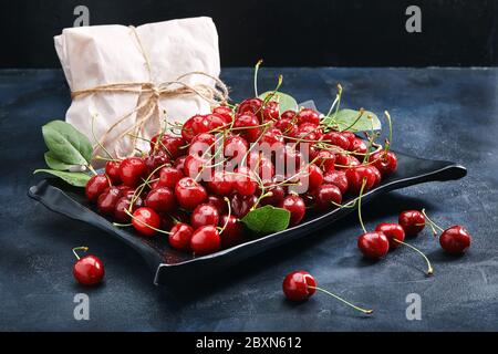 Frische süße Kirsche dunklen Hintergrund, umweltfreundliche Verpackung. Nahaufnahme Foto für Lebensmittelkatalog speichern. Stockfoto