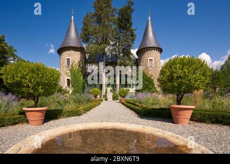 Schloss Picomtal (historisches Denkmal) mit seinen zwei Türmen und Sommergarten in Blüte. Les Crots, Hautes-Alpes, Provence-Alpes-Cote d'Azur Region, Frankreich Stockfoto