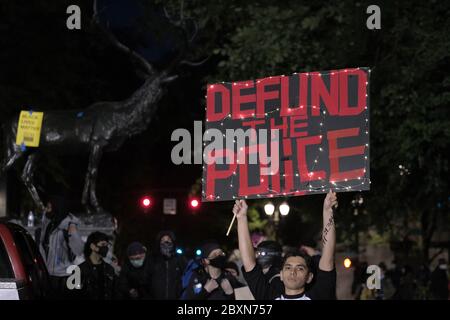 Portland, USA. Juni 2020. Ein Protestler hält ein Schild, das die Entfinanzierung der Polizei in der zehnten Nacht der Aktion gegen die Polizeibrutalität in Portland, Oregon, am 7. Juni 2020 fordert. (Foto: Alex Milan Tracy/Sipa USA) Quelle: SIPA USA/Alamy Live News Stockfoto