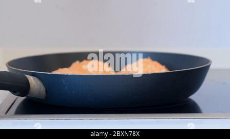 Koteletts in einer schwarzen Pfanne auf dem Herd gebraten. Stockfoto
