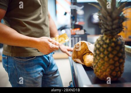 Männliche Person an der Kasse im Supermarkt Stockfoto