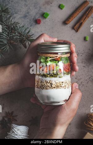 Weihnachts-Plätzchen Mixglas. Trockene Zutaten zum Kochen von Weihnachtskeksen in einem Glas, dunkler Hintergrund. Weihnachtsessen Konzept. Stockfoto