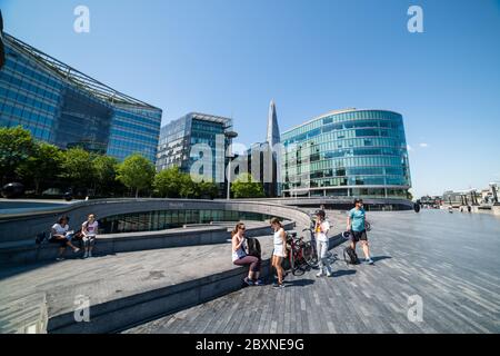 Ein schöner Tag auf dem Queens Walk, South Bank, London, Großbritannien, mit Menschen draußen genießen die Sonne. Stockfoto