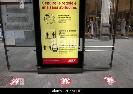 Straßenbahnhaltestelle mit sozialen Distanzschildern auf dem Boden für die Gesundheitssicherheit während der Covid-19-Krise, in Mailand, Italien. Stockfoto