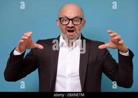 Reifer italienischer Mann posiert isoliert auf blaue Wand. Stockfoto