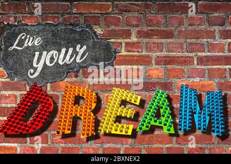 Die Worte Leben Sie Ihren Traum geschrieben auf einer roten Ziegelwand Stockfoto