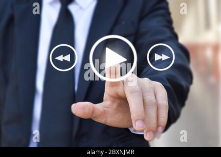 Geschäftsmann drücken Play-Taste zu starten. Idee für Business, Technologie und Präsentation. Stockfoto