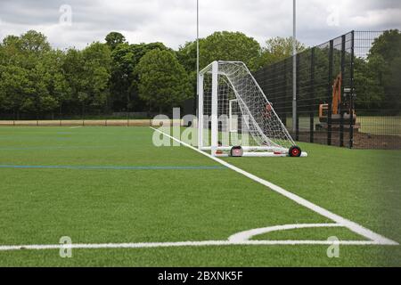 Ein neu installierter Allwetter-Schule Sportplatz mit Kunstrasen. Zeigt das Layout für Fußball mit Tor und Ecke des Spielfelds. London, Großbritannien. Stockfoto