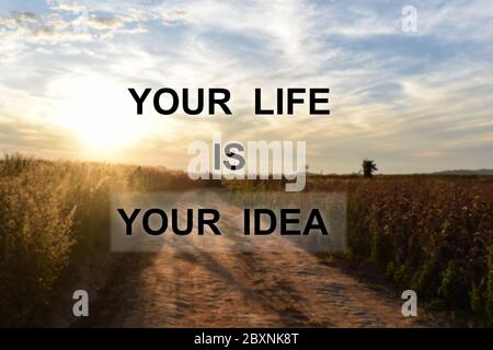 Inspirierendes Zitat auf Bergstraße bei Sonnenaufgang Hintergrund. Motivationszitate fürs Leben. Stockfoto