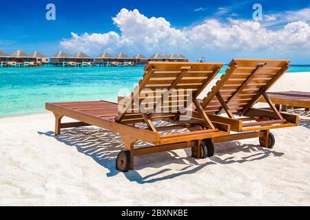 MALEDIVEN - 24. JUNI 2018: Holzsonnenliege am tropischen Strand auf den Malediven am Sommertag Stockfoto