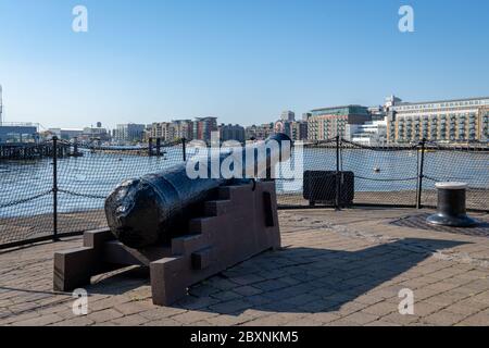 Eine alte gusseiserne Kanone, die auf Butler's Wharf entlang der Themse zeigt. Stockfoto