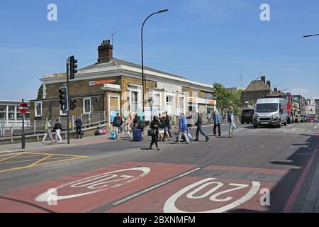 Neuer Cross Gate Bahnhof im Südosten Londons, Großbritannien. Zeigt Fußgänger, die die verkehrsreiche A2-Bundesstraße überqueren. Stockfoto