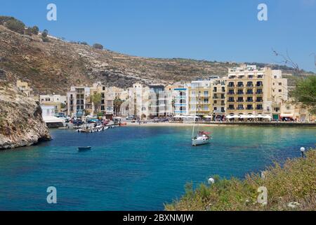 Xlendi Bucht auf Maltas Gozo Insel mit wunderschönen dunkelblauen Wasser und historischen Dorf Xlendi. Tiefblaues Wasser und Sandstrand auf der Insel Gozo mit p Stockfoto