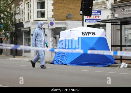 Ein Gerichtsbeamter in einem Polizeizelt am Tatort in Askew Road, Shepherd's Bush, West London, als eine Morduntersuchung eingeleitet wurde, nachdem ein Mann erschossen wurde. Das Opfer, das vermutlich um die 20 Jahre war, wurde in den frühen Morgenstunden des Montags mit Schusswunden gefunden. Stockfoto