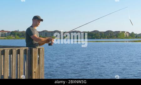 Fischer werfen Angelrute in See oder Fluss Wasser. Stockfoto