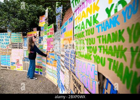 Hermine Wilson hilft bei der Installation eines neuen Kunstwerks im Jupiter Artland, Edinburgh, das als Hommage an das NHS mit dem Titel 'A Thousand Thank Yous' entstand, das ursprünglich vom verstorbenen Allan Kaprow entworfen wurde und aus bunt gemalten Botschaften auf Karton besteht und von dem Londoner Künstler Peter Liversidge ferngesteuert inszeniert wurde. Stockfoto