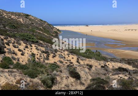 Portugal, Algarve, Aljezur, Praia da Bordeira. Panorama des Atlantischen Ozeans, der sich an einem unberührten goldenen Sandstrand an der portugiesischen Westküste befindet. Stockfoto